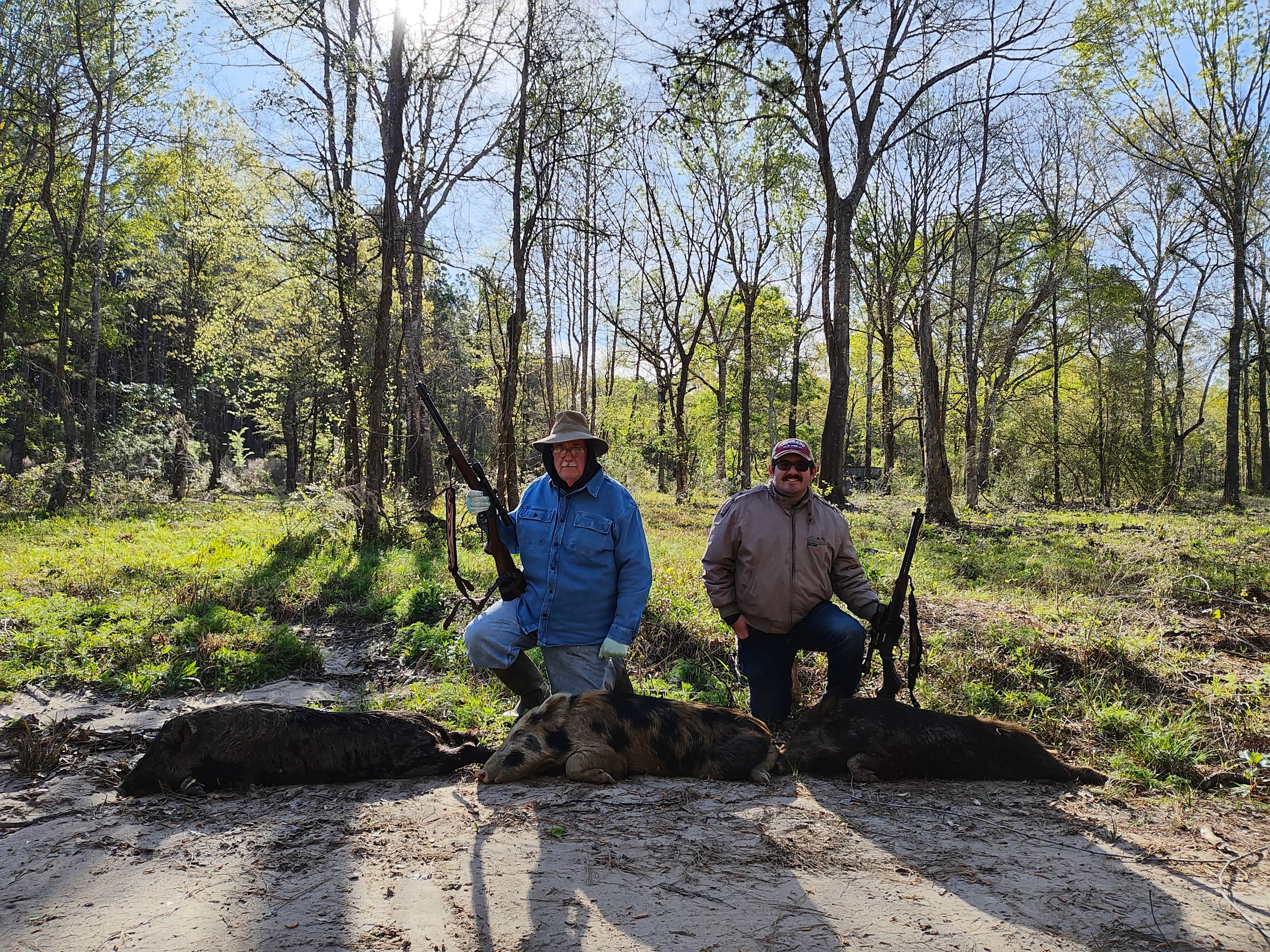 The author and his father standing behind three harvested hogs
