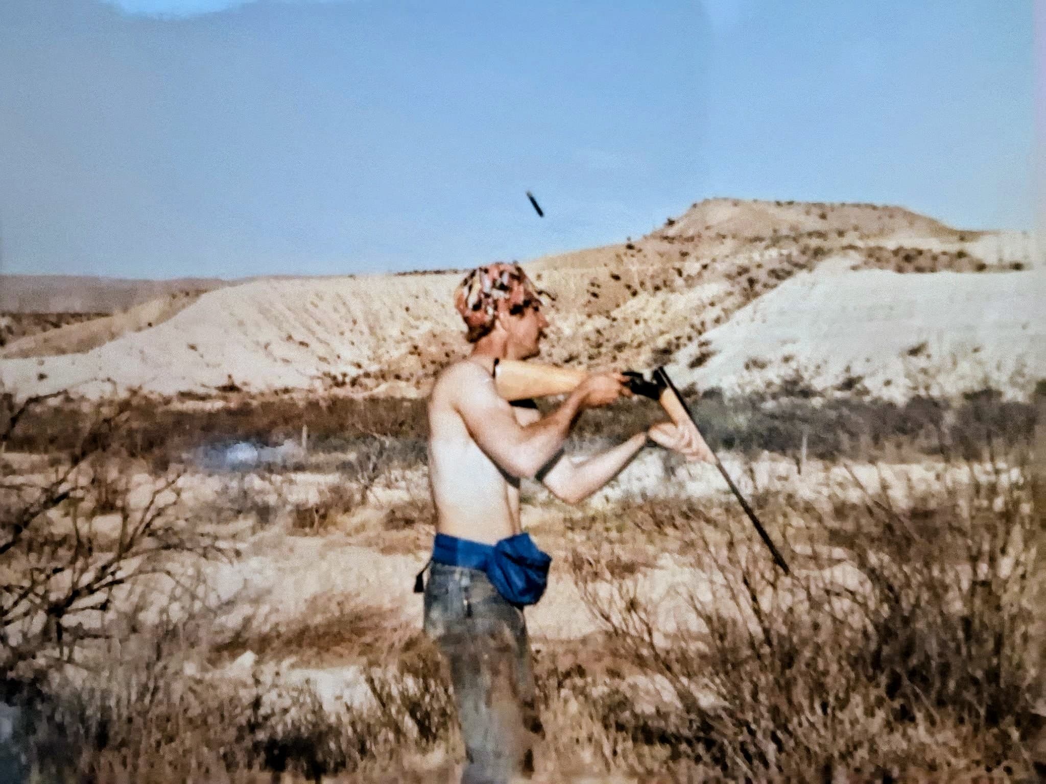 A quail hunter ejecting a shotgun shell in the Brewster County desert